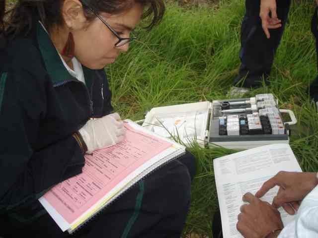 Estudiante registrando los datos de algunas pruebas químicas y físicas